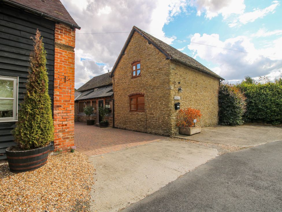 An outdoor view of a stone house with a driveway and plants at The Old Farmhouse in Westhope