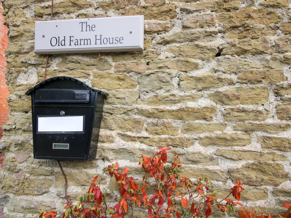 A sign and mailbox on a stone wall at The Old Farmhouse in Westhope