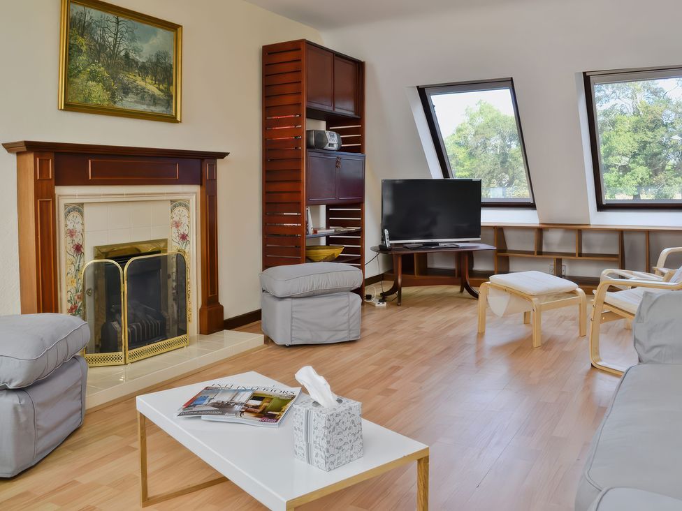 A living room with a fireplace and tv at Sisial y Llyn in Bala