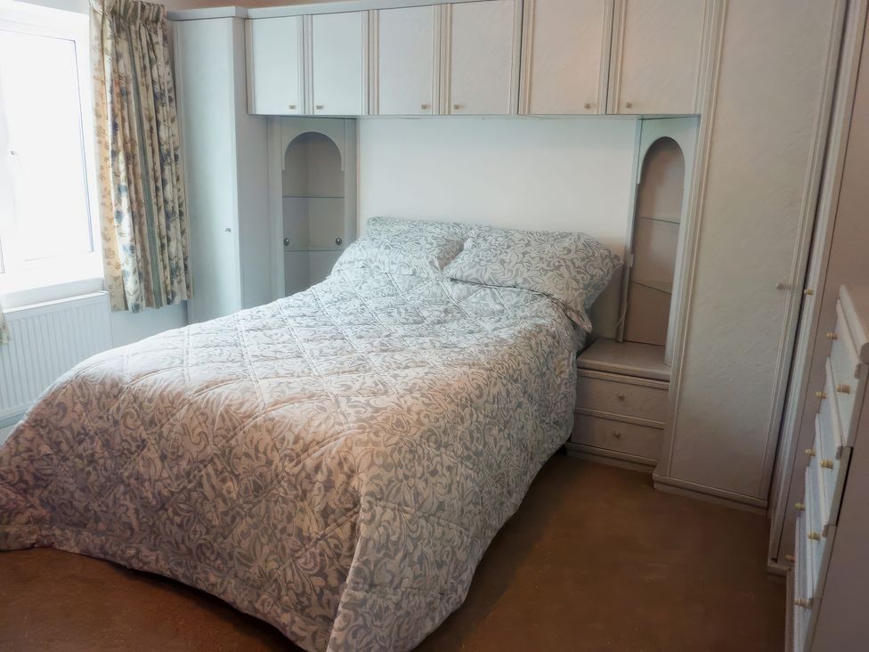 A bedroom with a bed and wardrobe at Sisial y Llyn in Bala