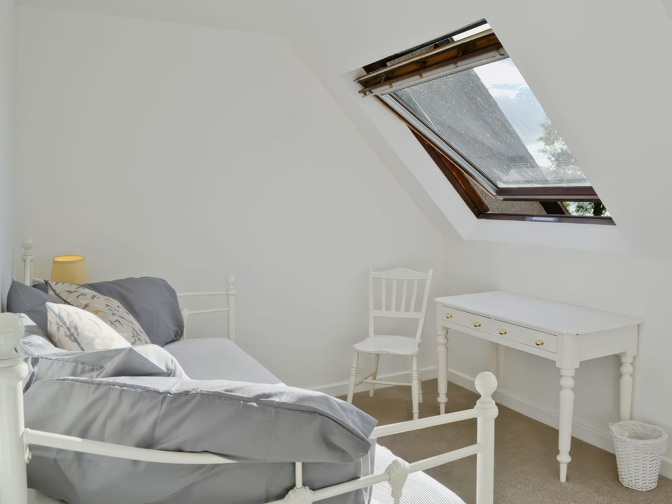 A bedroom with a bed and a desk in Sisial y Llyn Bala