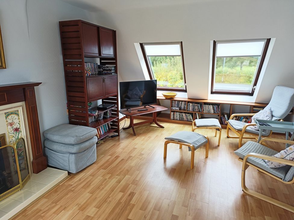 A living room with a tv and bookshelf at Sisial y Llyn in Bala
