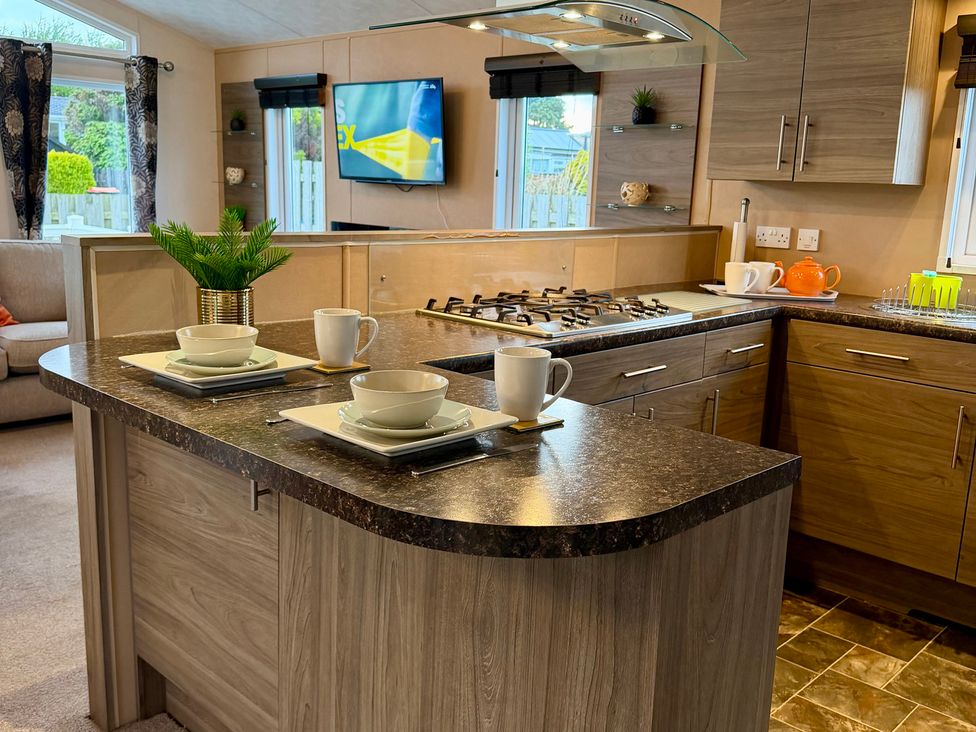 A kitchen with an island and stove at Cheri in Southerness