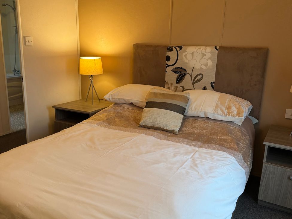 A bedroom with a bed and nightstand at Cheri in Southerness