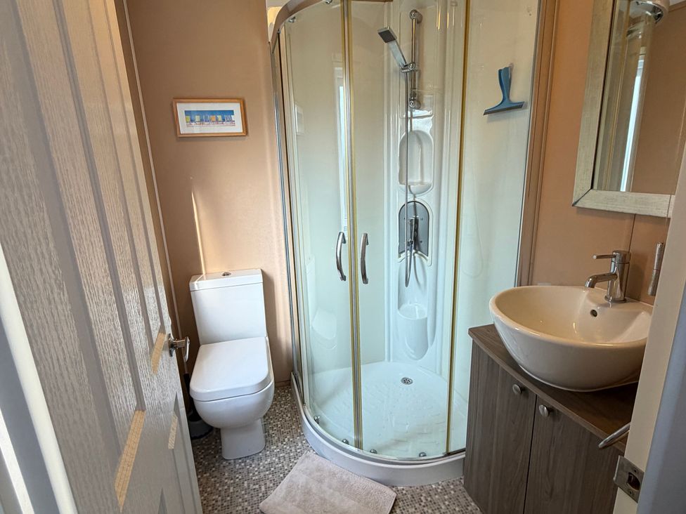 A bathroom with a shower, toilet, and sink at Cheri in Southerness