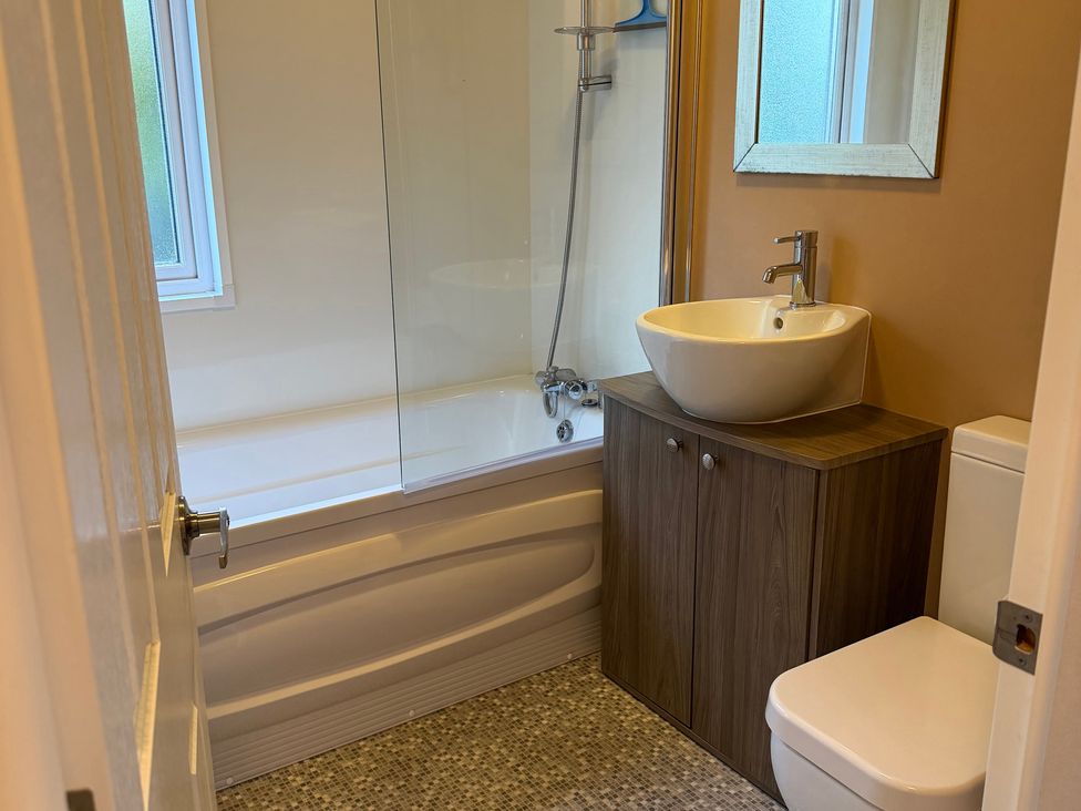 A bathroom with a bathtub, sink, and toilet at Cheri in Southerness
