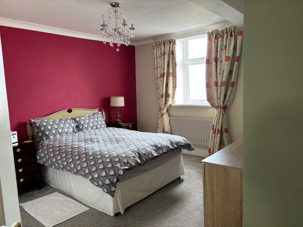 A bedroom with a double bed and bedside table at Greenmantle in Skinburness near Silloth, Solway Firth
