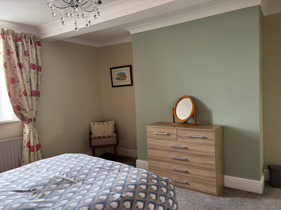A bedroom with a bed and dresser at Greenmantle in Skinburness near Silloth, Solway Firth