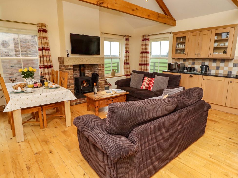 A living room with a sofa and dining area at West Gate in Embleton