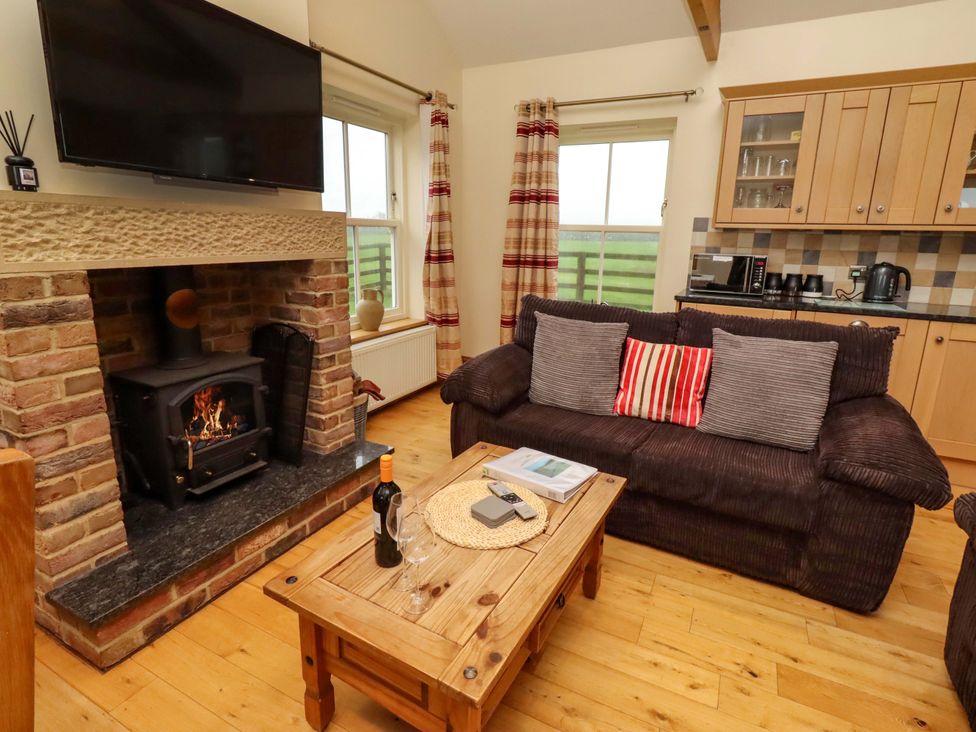 A living room with a fireplace and sofa at West Gate in Embleton