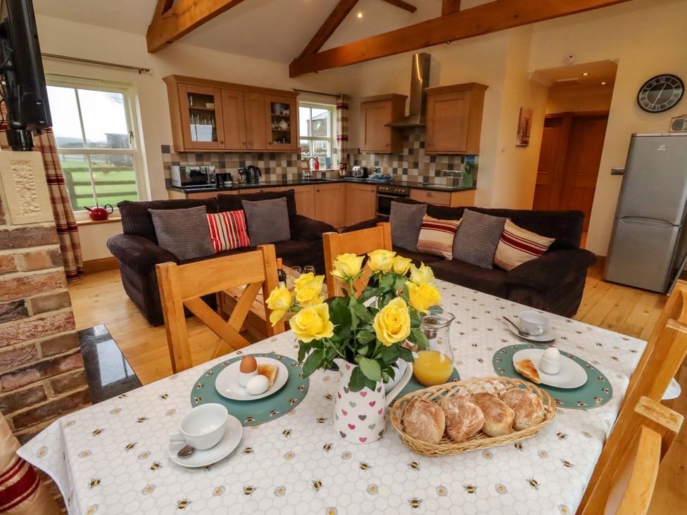 A dining room with a table and flowers at West Gate in Embleton
