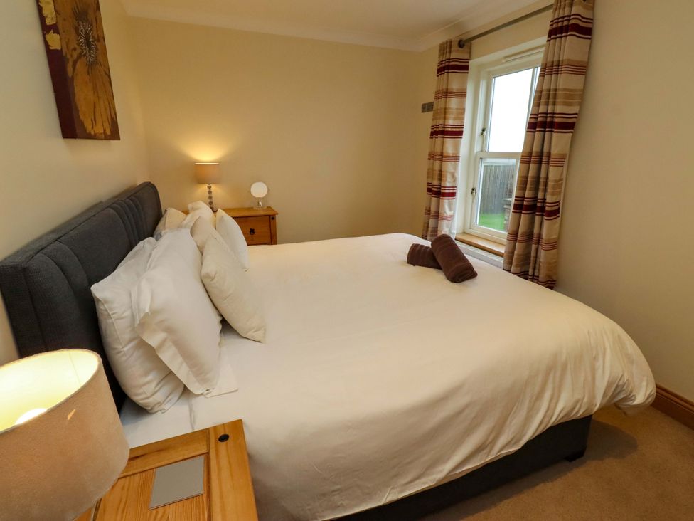 A bedroom with a bed and bedside table at West Gate in Embleton