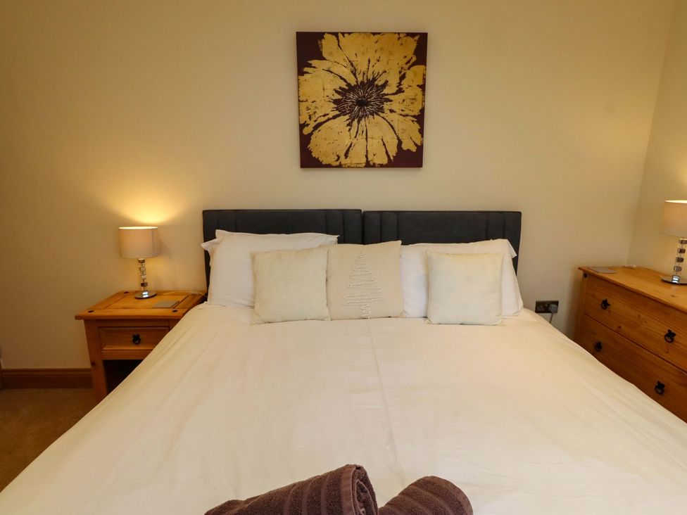 A bedroom with a bed and bedside table at West Gate in Embleton