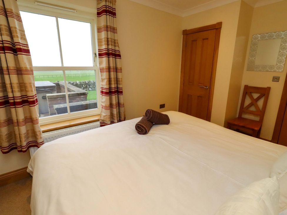 A bedroom with a bed and window at West Gate in Embleton