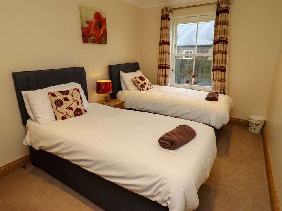 A bedroom with two twin beds and a window at West Gate in Embleton