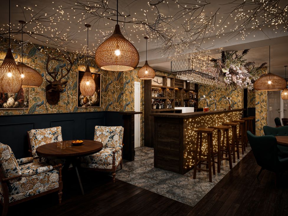 A bar with stools and decorative lighting at Poacher's Arms in Hope