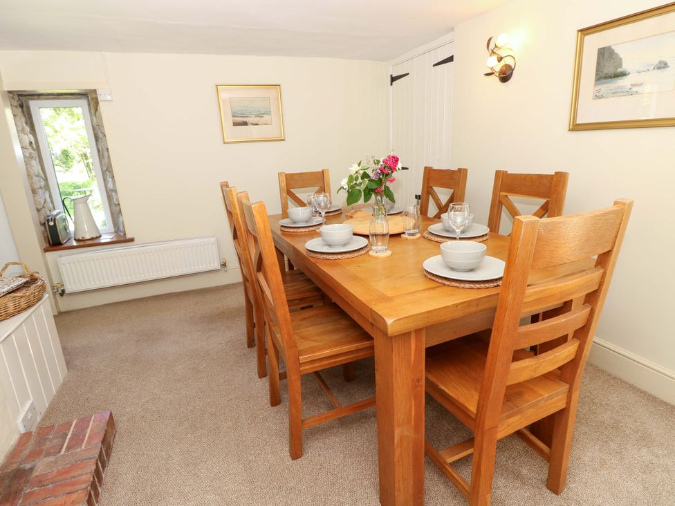 A dining room with a wooden table and chairs at Sweet Briars in Chale