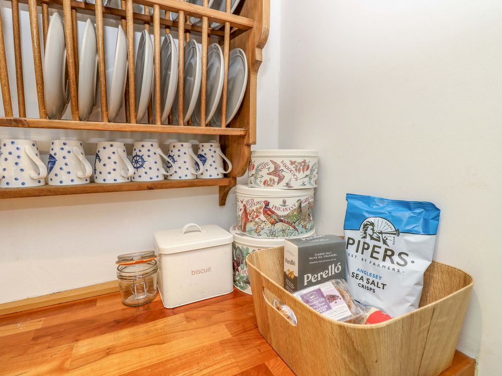 A kitchen area with plates and mugs on a rack at Sweet Briars in Chale