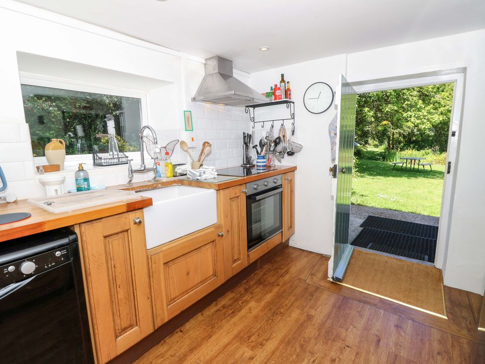 A kitchen with a sink, oven, and window at Sweet Briars in Chale