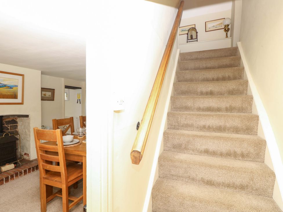 A staircase leading to the upper level with a dining area at Sweet Briars, Chale