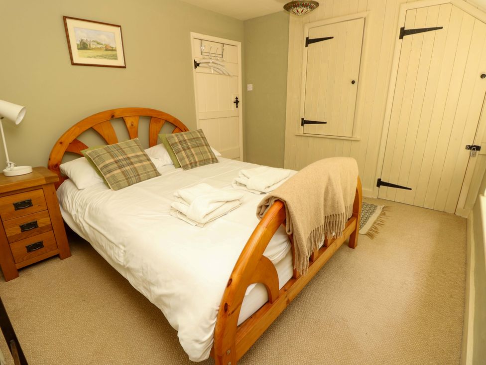 A bedroom with a bed and nightstand at Sweet Briars in Chale