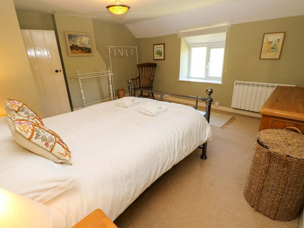 A bedroom with a bed and a chair at Sweet Briars in Chale