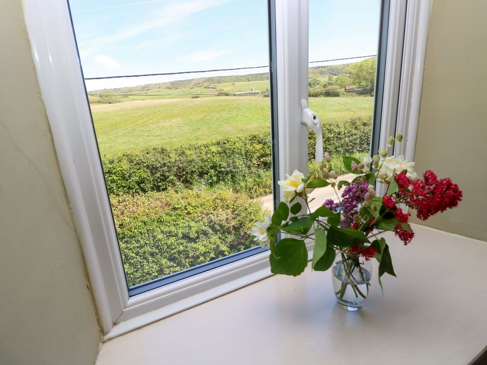 A window with flowers in a vase at Sweet Briars in Chale