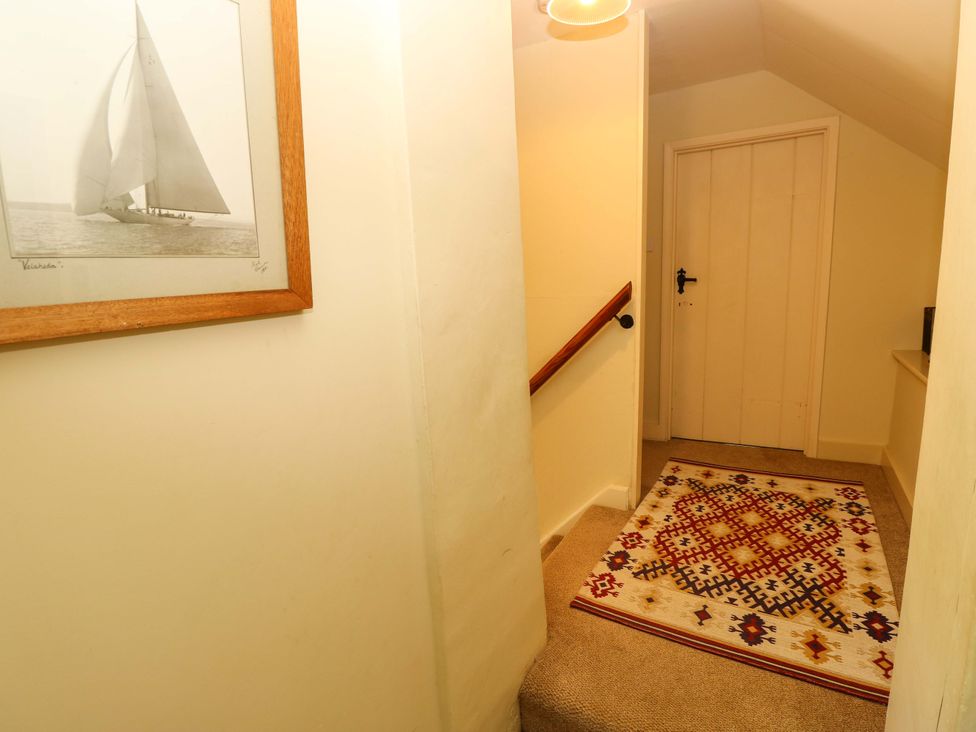 A hallway with stairs and a rug at Sweet Briars in Chale
