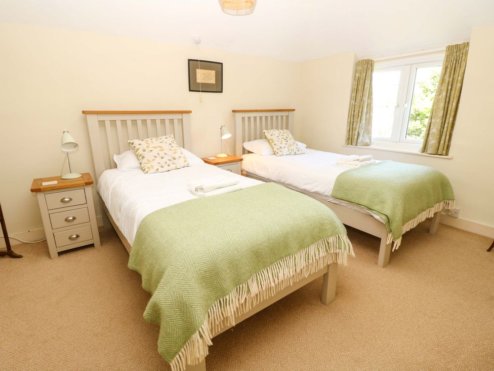 A bedroom with two beds and side tables at Sweet Briars in Chale
