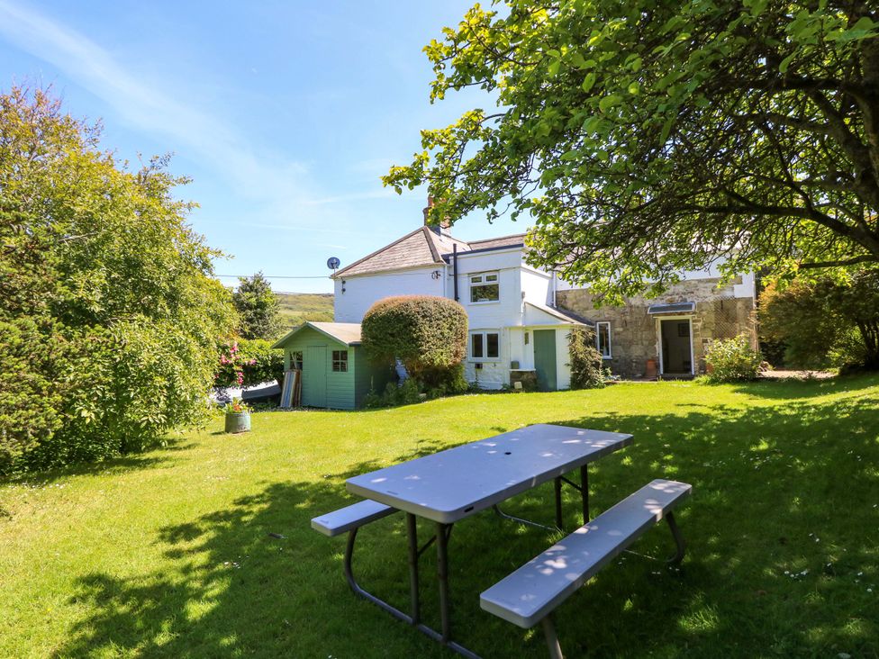 A garden with a table and benches at Sweet Briars in Chale