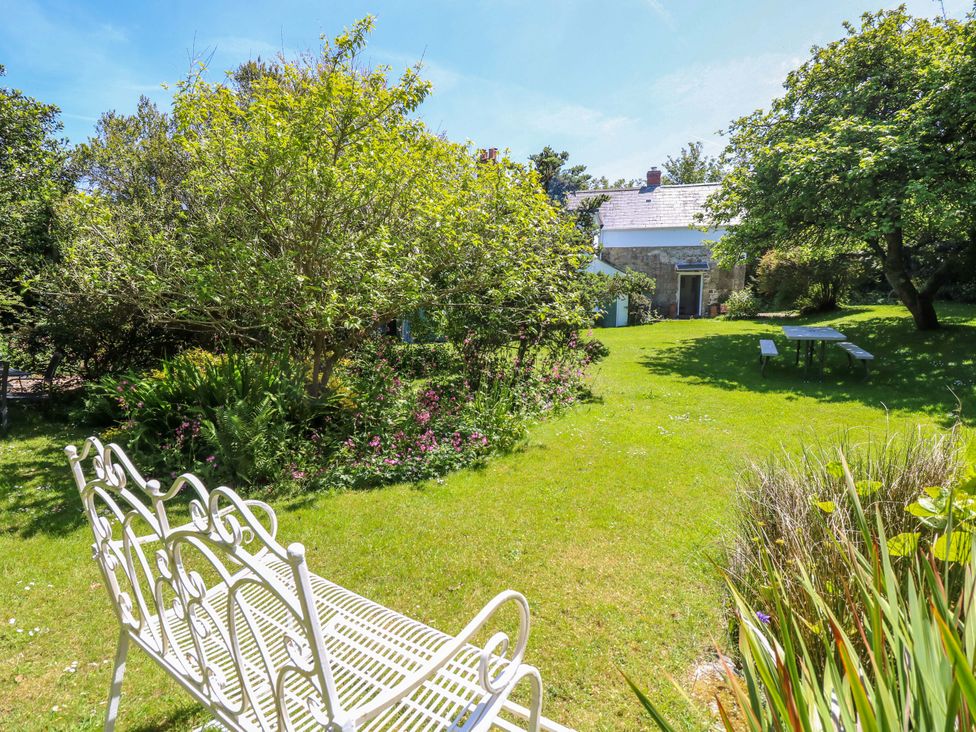 A garden with a bench and table at Sweet Briars in Chale