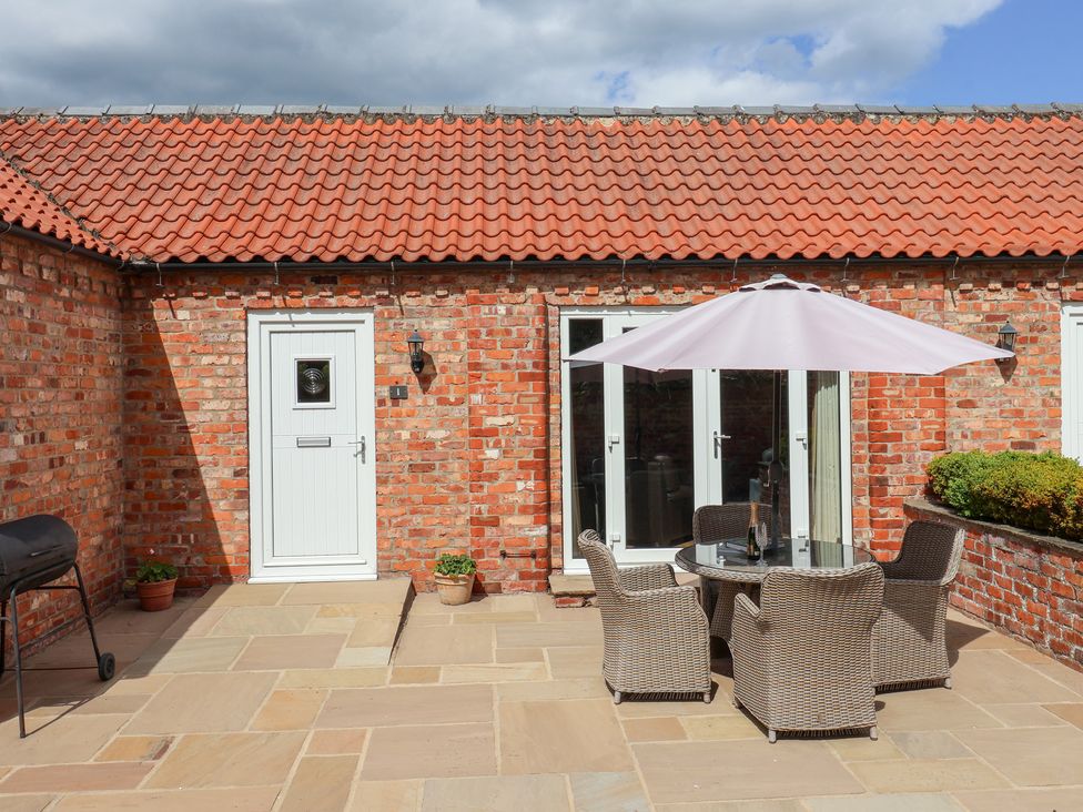 An outdoor seating area with a table and chairs at Winsall Court I Gransmoor near Bridlington