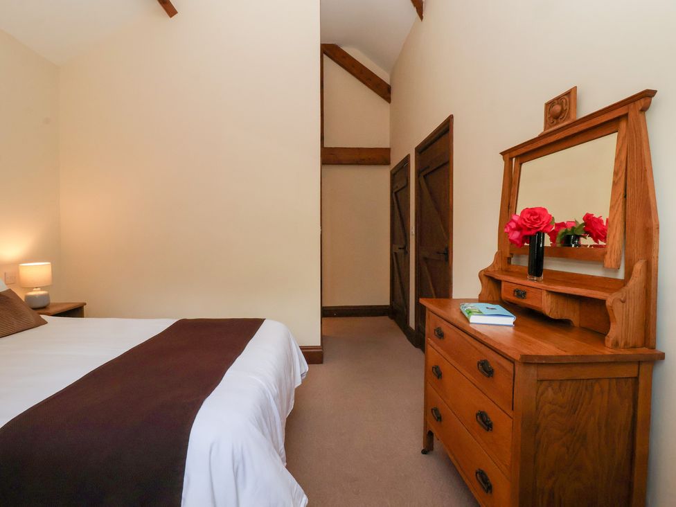 A bedroom with a bed and a dressing table at Winsall Court I Gransmoor near Bridlington