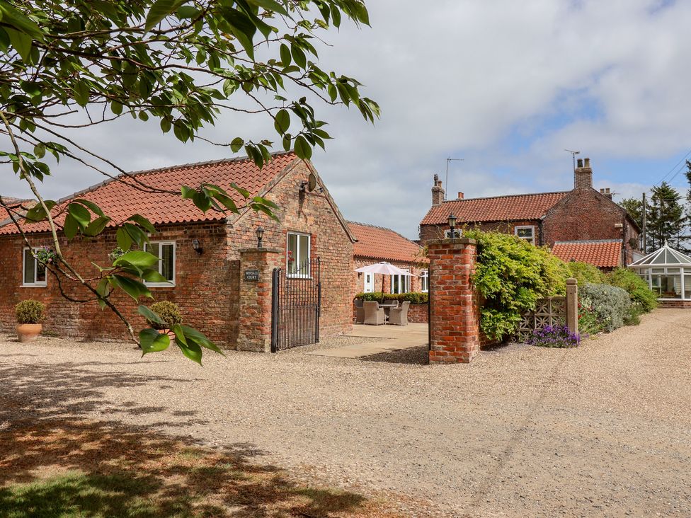An outdoor area with brick buildings and plants at Winsall Court I Gransmoor near Bridlington