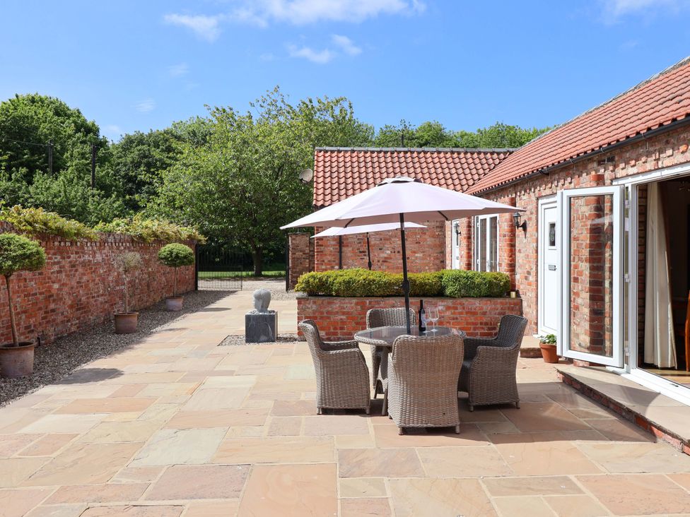 An outdoor seating area with a table and chairs at Winsall Court II Gransmoor near Bridlington
