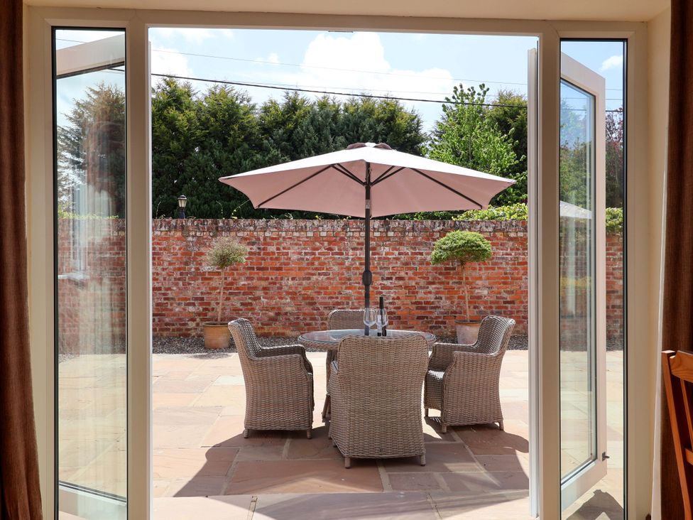 An outdoor seating area with a table and chairs under an umbrella at Winsall Court II Gransmoor near Bridlington