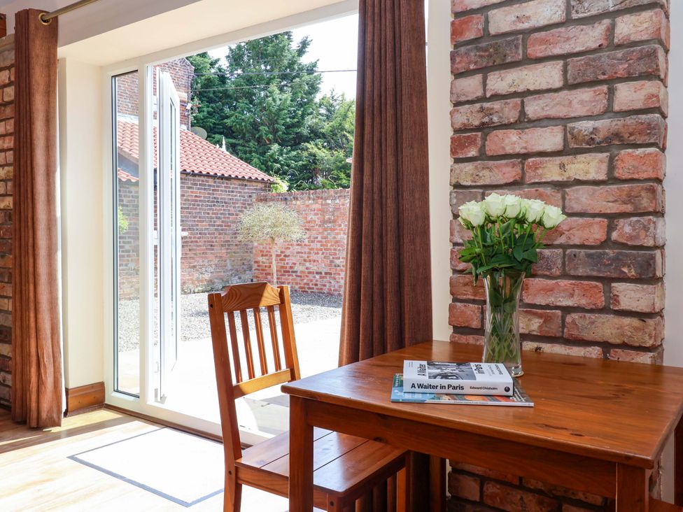 A dining area with a table and chairs at Winsall Court II Gransmoor near Bridlington