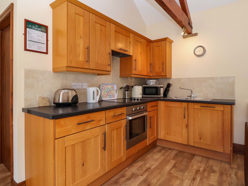 A kitchen with wooden cabinets and appliances at Winsall Court II Gransmoor near Bridlington