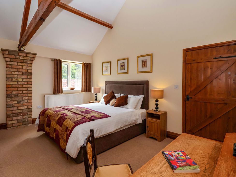 A bedroom with a bed and bedside table at Winsall Court II in Gransmoor near Bridlington