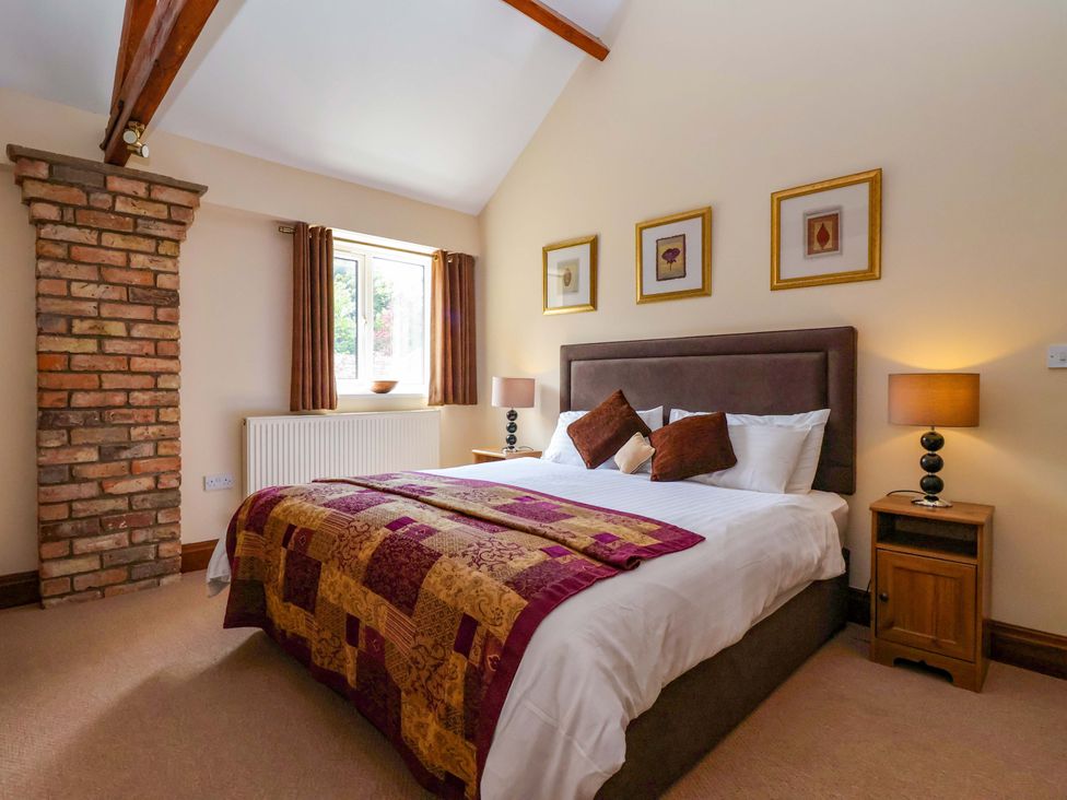 A bedroom with a bed and window at Winsall Court II Gransmoor near Bridlington