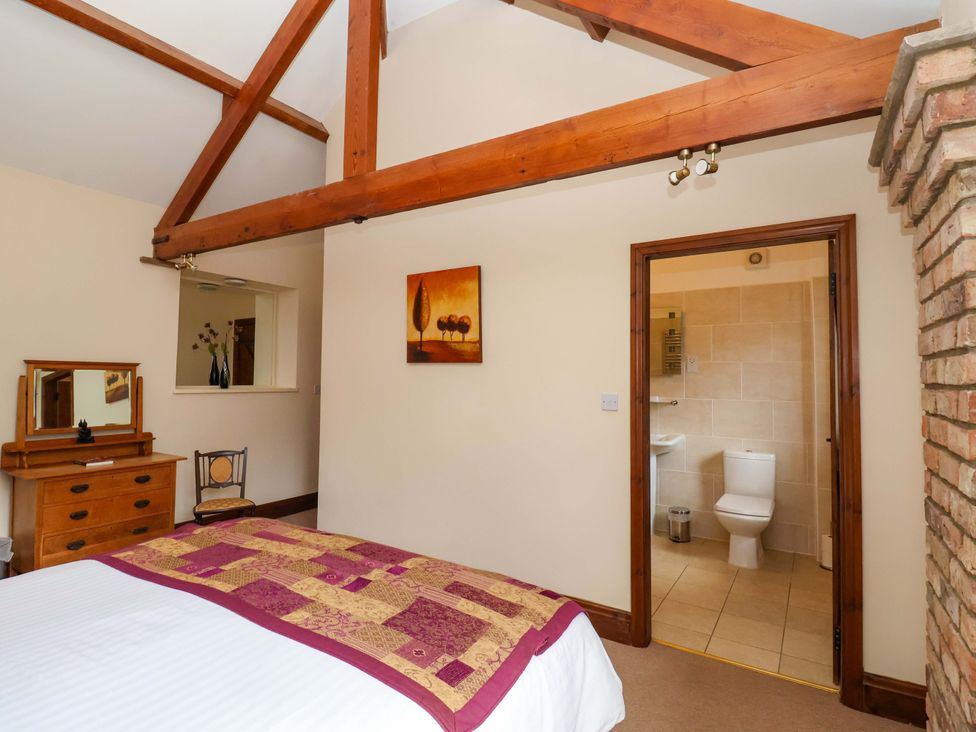 A bedroom with a bed and attached bathroom at Winsall Court II Gransmoor near Bridlington