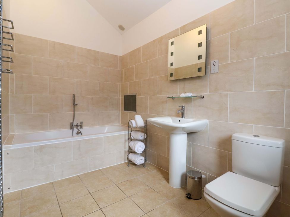 A bathroom with a bathtub and sink at Winsall Court II Gransmoor near Bridlington