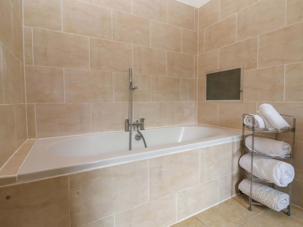 A bathroom with a bathtub and towels on a rack at Winsall Court II Gransmoor near Bridlington