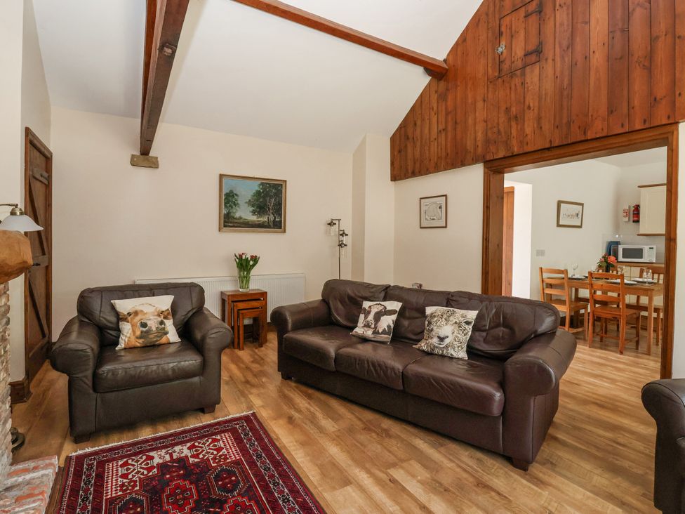 A living room with brown furniture and a kitchenette at The Wagon Shed in Gransmoor near Bridlington