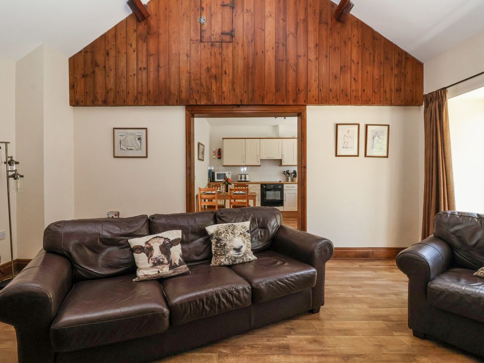 A living room with sofa and dining area at The Wagon Shed in Gransmoor near Bridlington