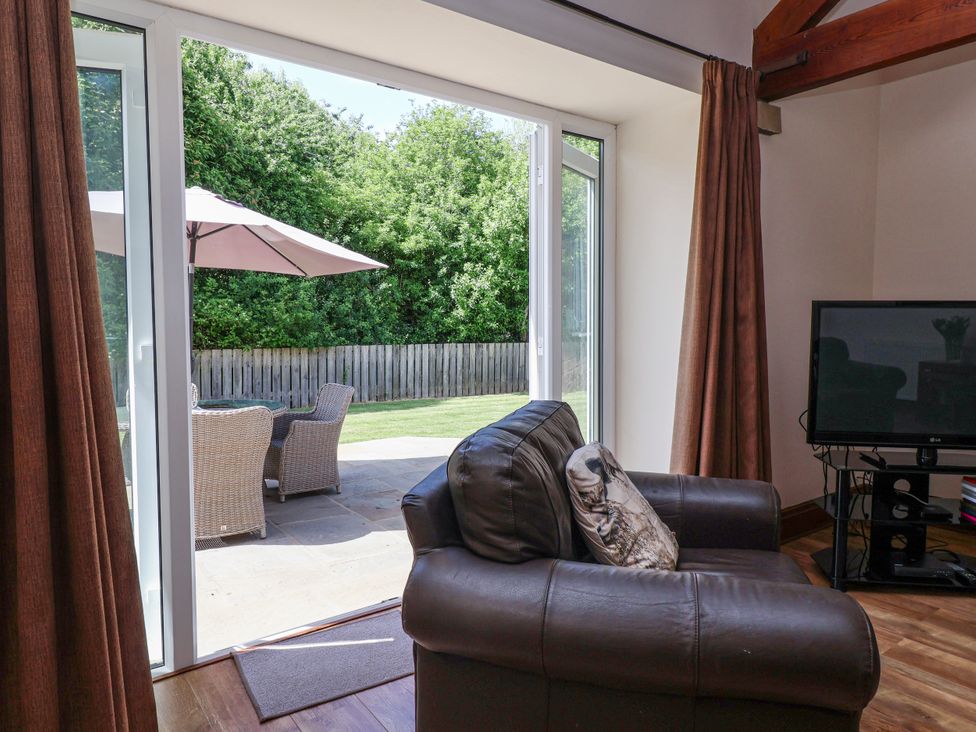 A living room with a chair and television at The Wagon Shed in Gransmoor near Bridlington