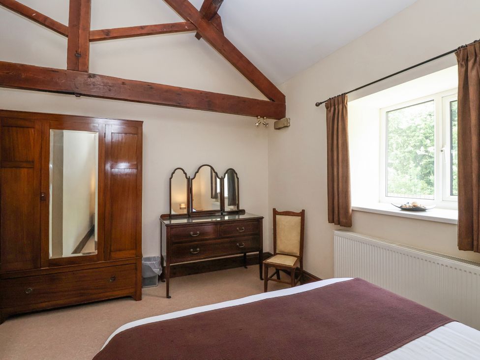 A bedroom with a wardrobe and dressing table at The Wagon Shed in Gransmoor near Bridlington