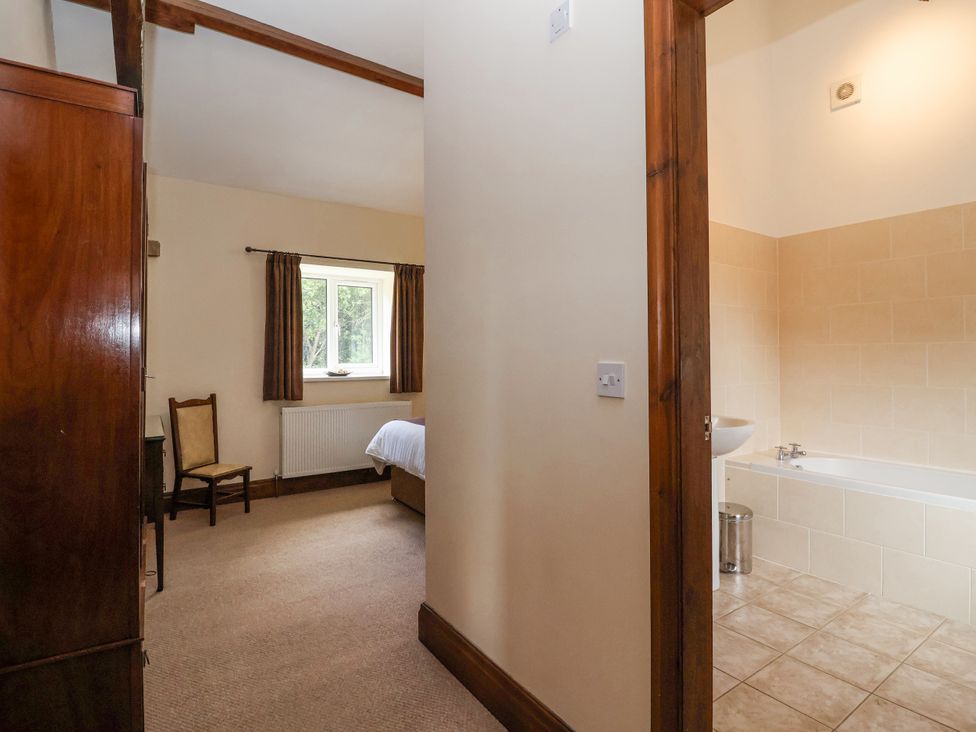 A bedroom with a bed and chair at The Wagon Shed in Gransmoor near Bridlington