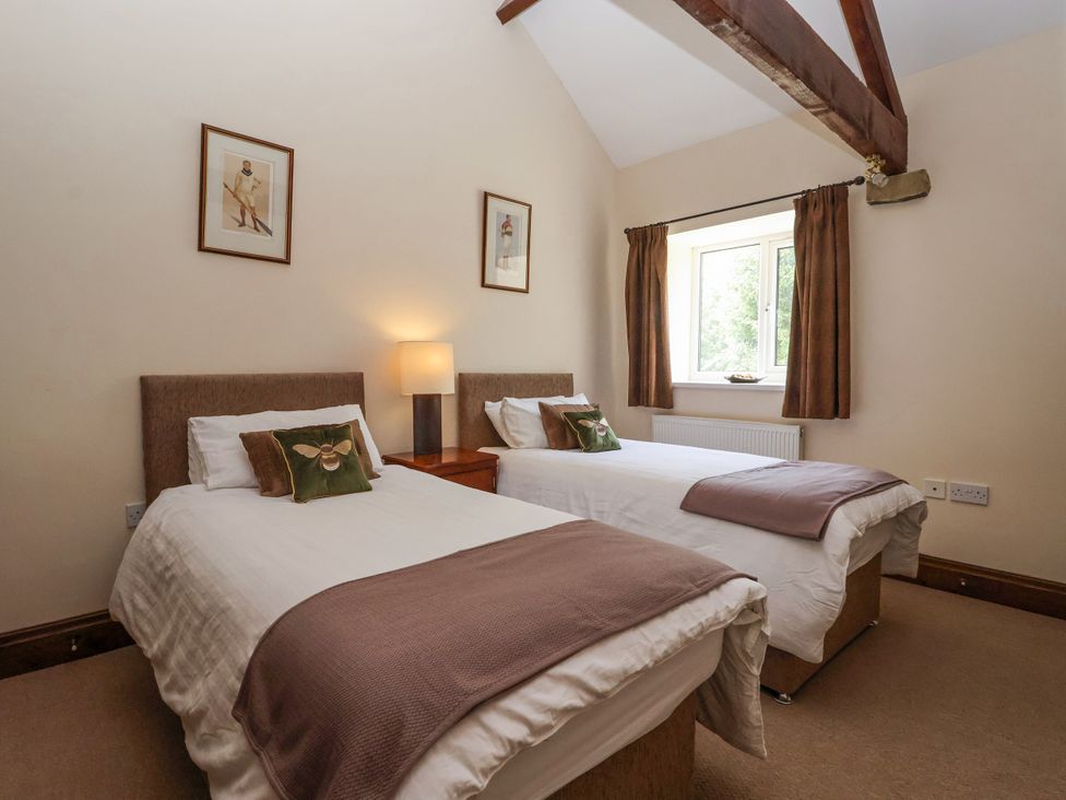 A bedroom with two beds and window at The Wagon Shed in Gransmoor near Bridlington