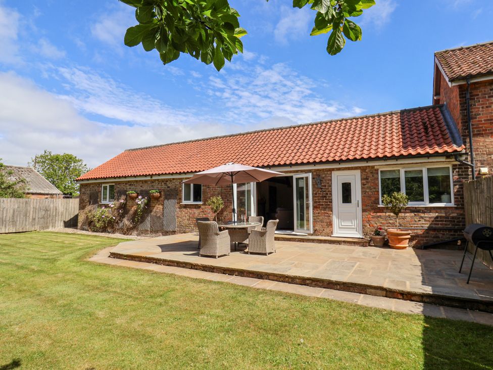A garden with a house and patio furniture at The Wagon Shed in Gransmoor near Bridlington